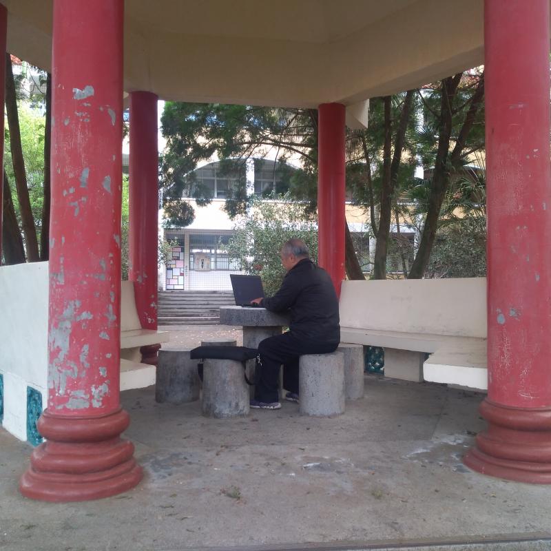 涼亭下，社區民眾透過校園無線網路，悠遊自在的上網，是校園角落的風景