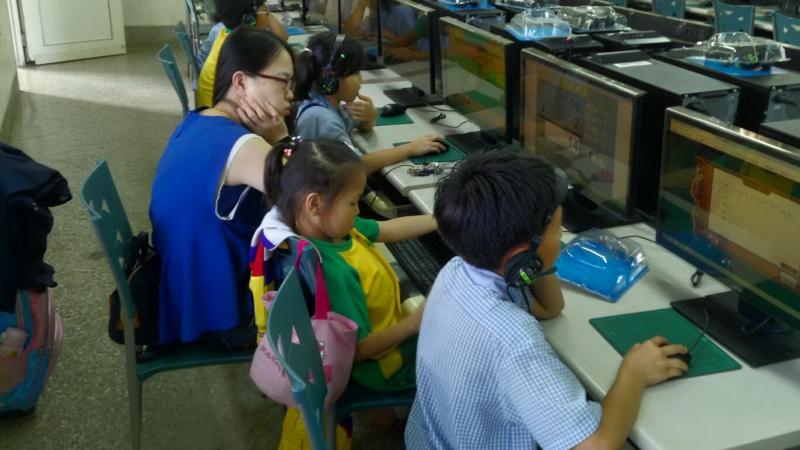 媽媽陪著孩子運用電腦程式自動出題練習四則運算