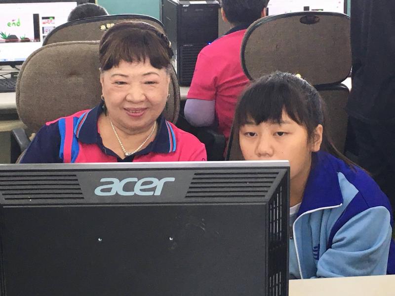學生協助社區奶奶學習操作電腦