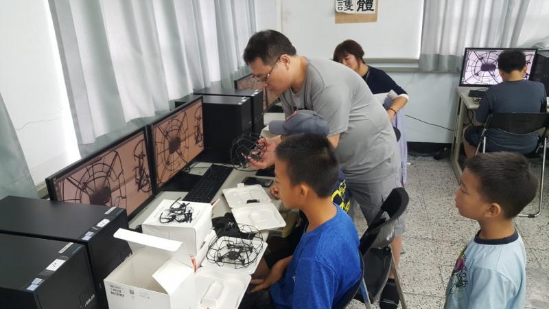 講師指導將無人機裝上保護罩
