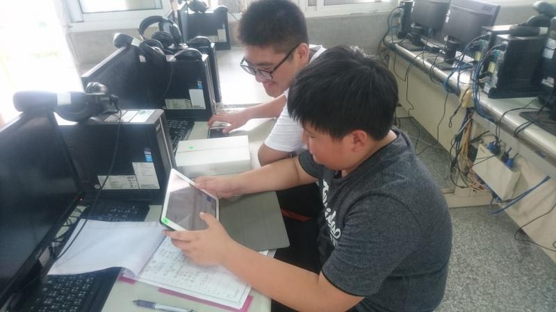 學生使用平板電腦一起討論完成作業