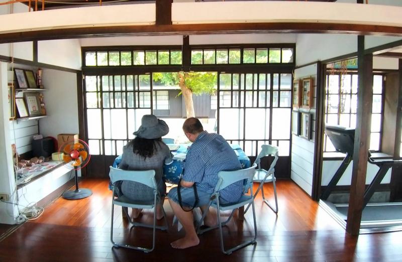 經過介紹之後，遊客對於日式建築的興趣濃厚，使用平板用心探索。