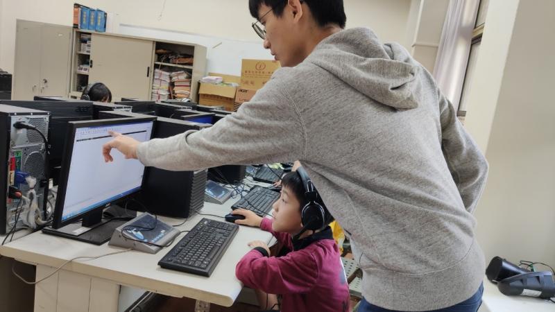 教師個別指導學生操作電腦