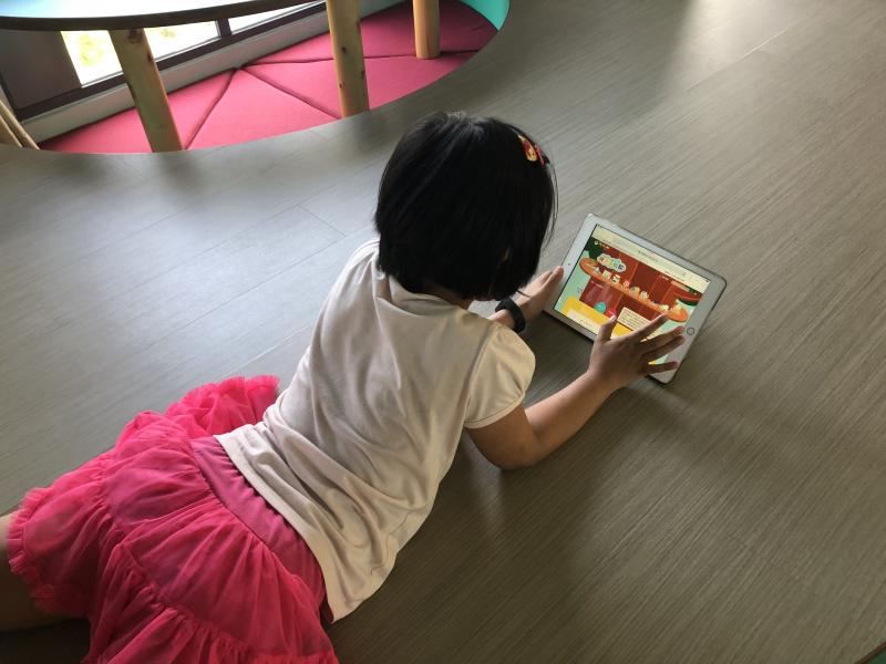 小朋友使用平板觀看繪本花園網的書
