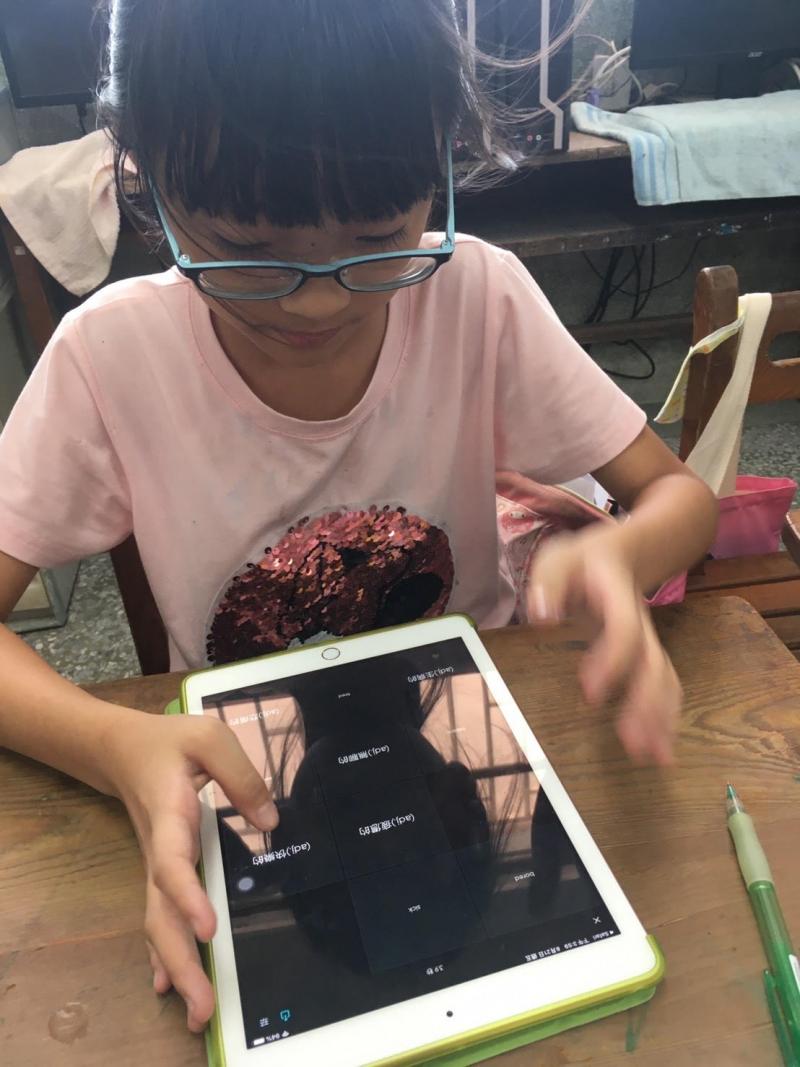 這位孩子, 因剛背完單字, 馬上玩單字配對, 因為背對成功, 臉上掛著微笑, 有成就感!