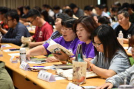 專注地看著交流會的手冊內容