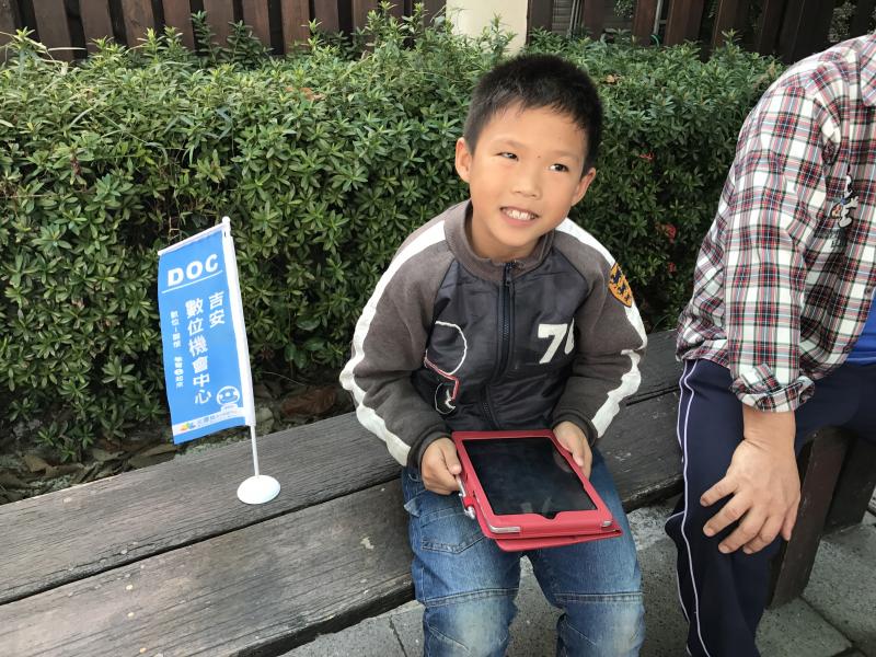 小朋友開心的捧著平板遊玩