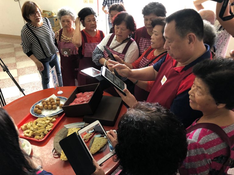 學員將手機拿出，拍攝桌上的料理。