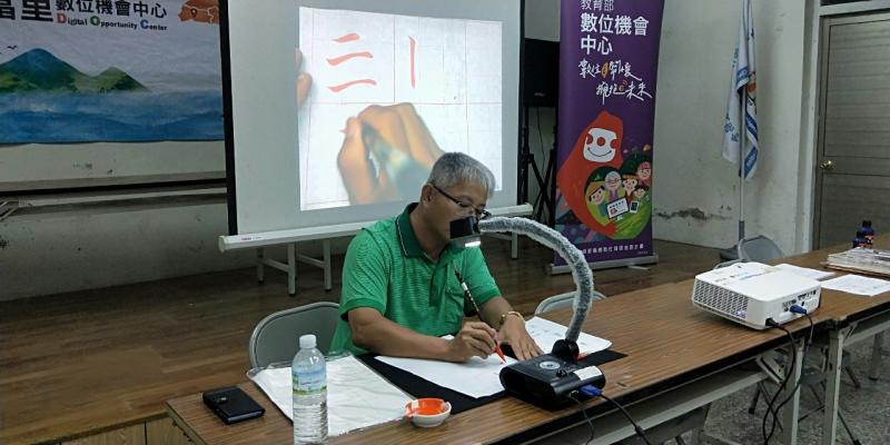 中城國小蔡國昌主任透過實物透影機帶領學員學習運筆。