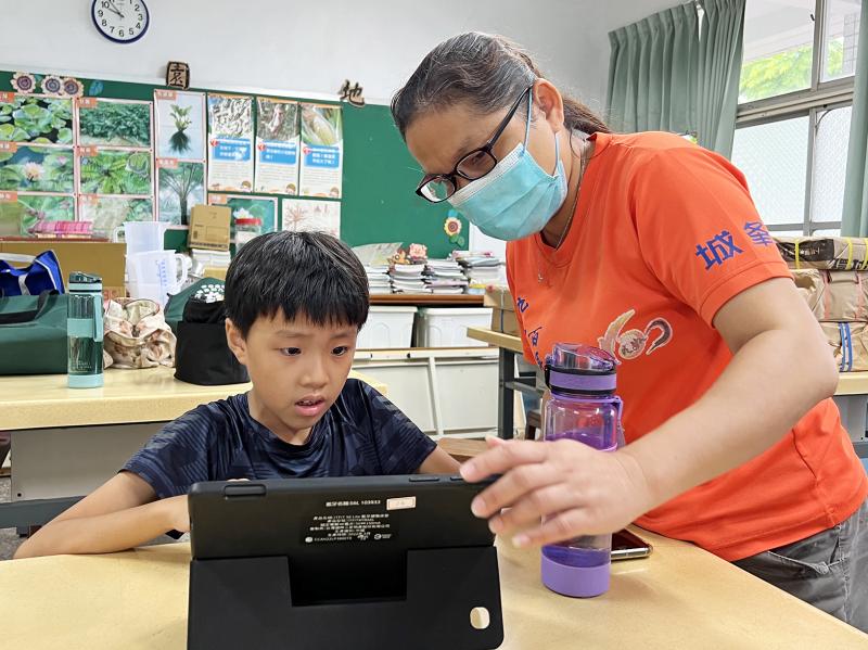 年輕阿嬤與孫兒一起認真研究題目