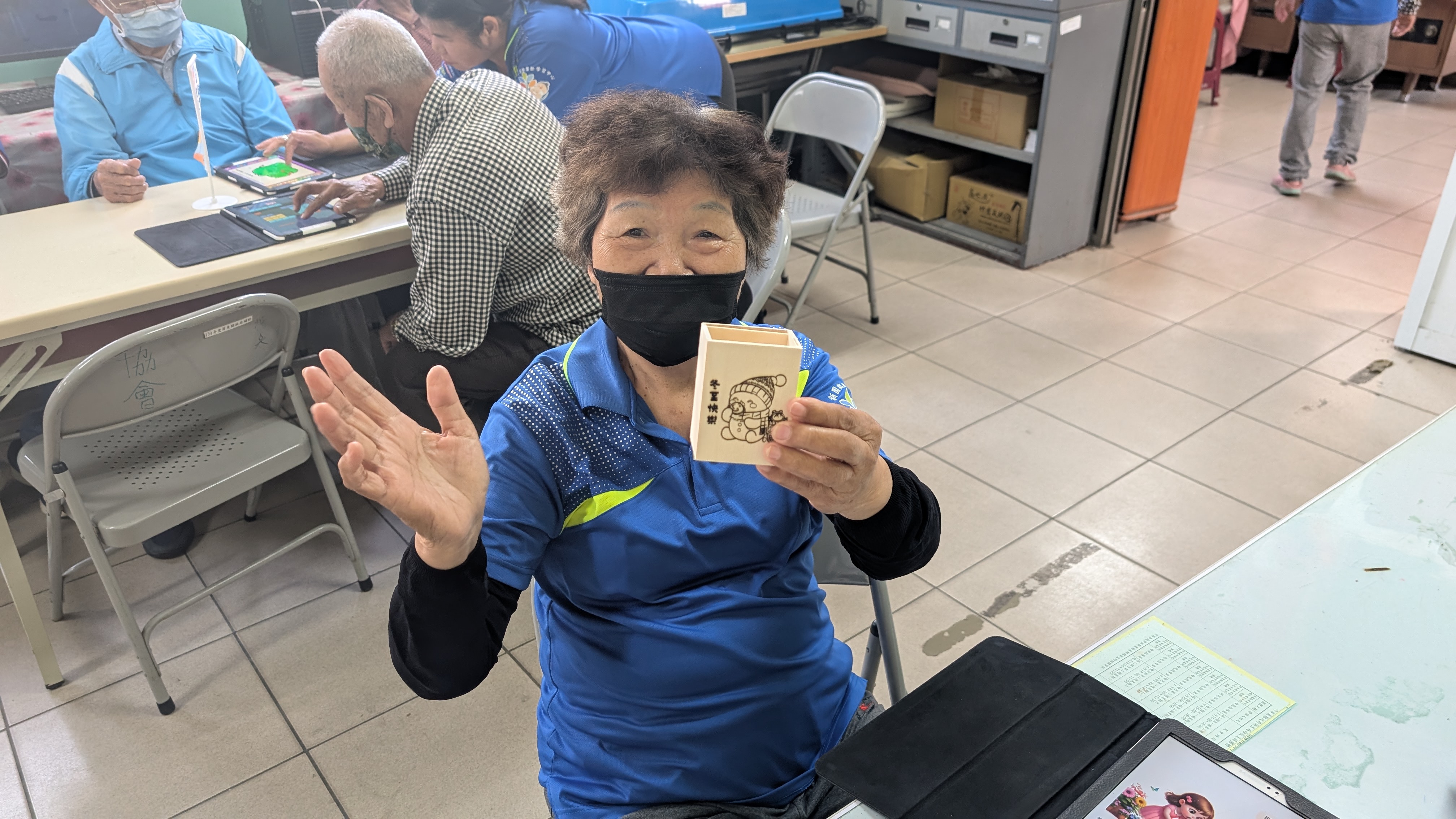 長者與自己的作品作拍攝的動作