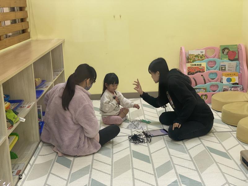 孩子在家長的陪伴下，進到教室進行錄音。
