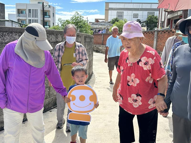 太陽高照也擋不住我們的熱情！長輩們牽著孩子的手，一起踏上社區健走的路程，小朋友還拿著可愛的笑臉立牌當領隊，超吸睛～大家一邊走路一邊聊日常，笑聲不斷，走著走著就更靠近彼此了，這才是真正的「健康一起走」！