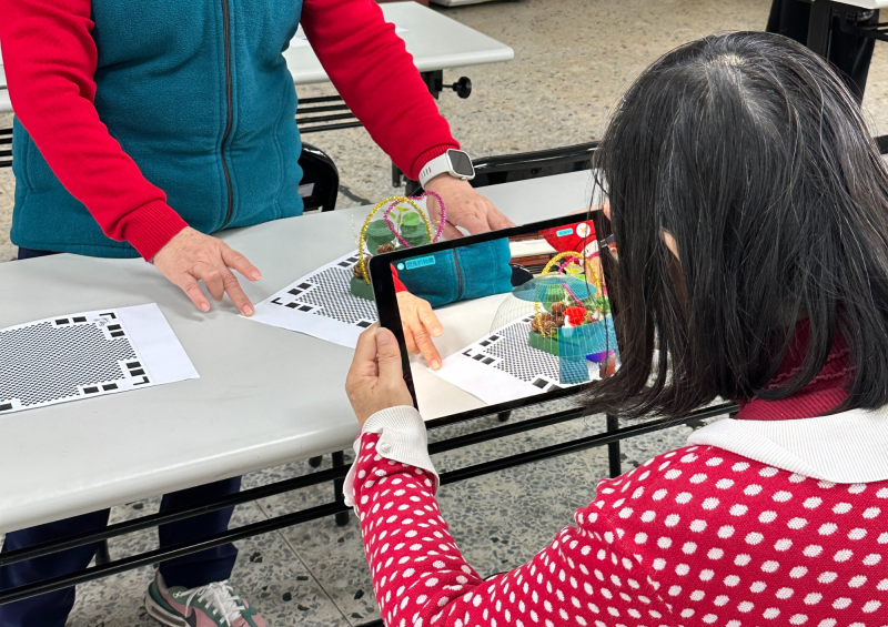 長輩們互相幫忙,相互練習平板操作。