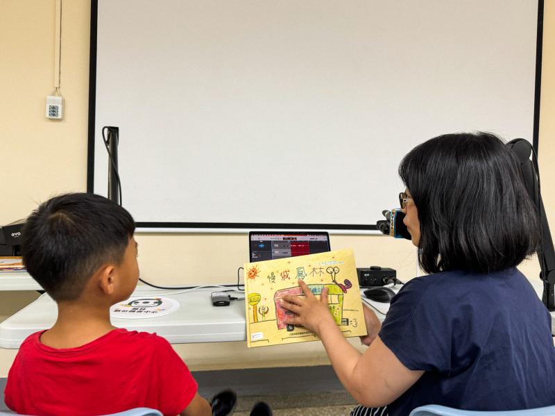 孩子們輪流對著麥克風大聲朗誦繪本內容｜家長則在一旁協助或引導對話