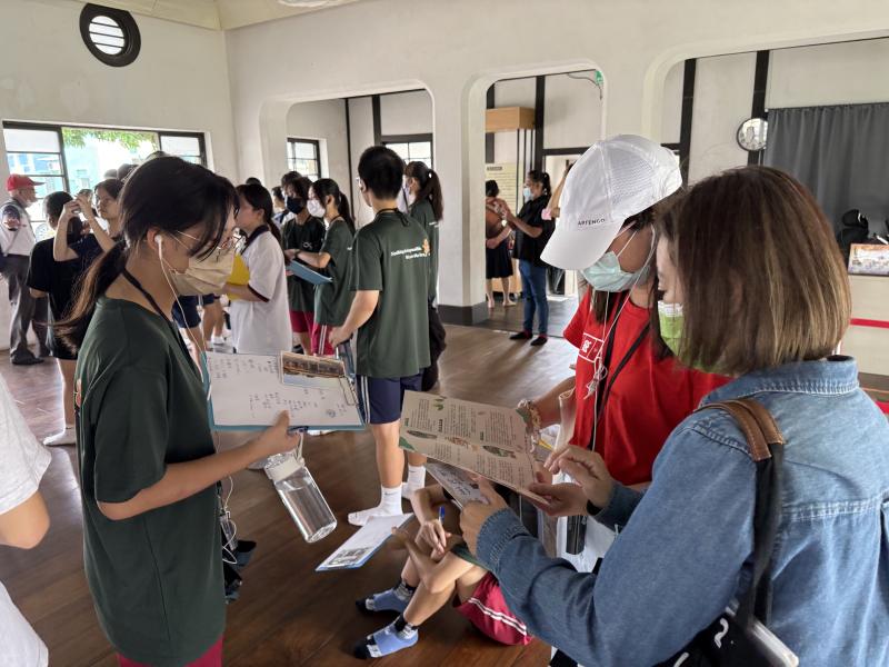 學生透過解說志工與明信片的輔助解說更瞭解景點的故事