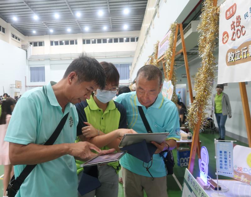 推廣人員透過 iPad 示範數位服務操作，協助民眾實際體驗智慧科技。