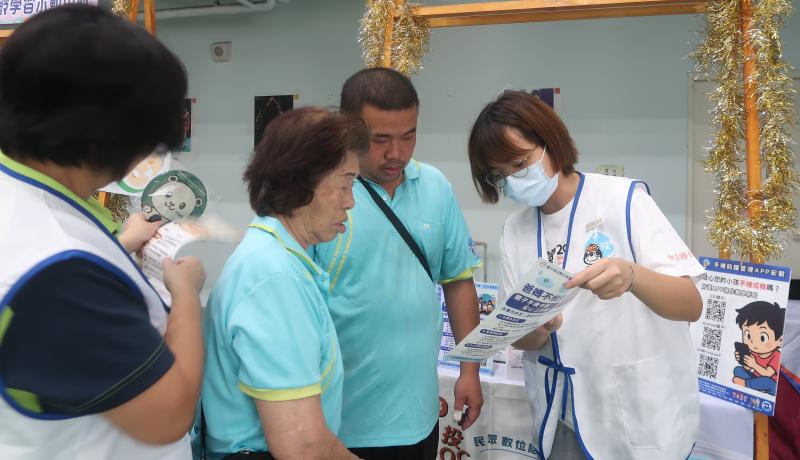小幫手向阿公阿嬤介紹手機防護觀念，並發放宣導資料，讓防詐知識深入社區。