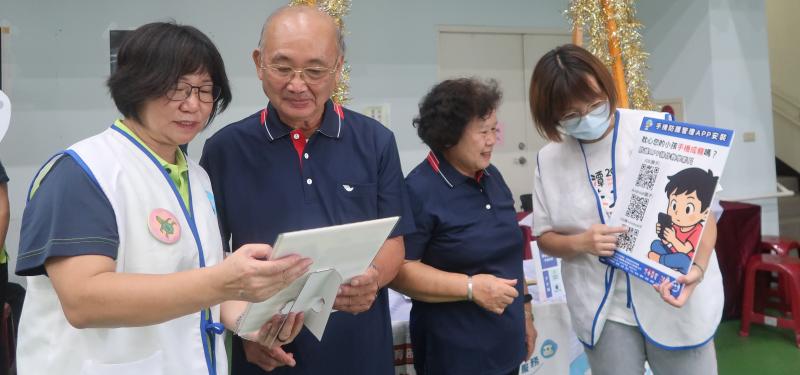 小幫手們分別與居民長輩交流，耐心說明手機防護方法，現場互動熱絡。