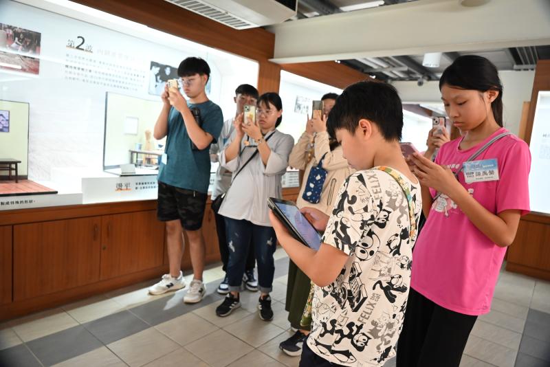 參賽隊伍在藺草文化館內進行闖關，用手機掃描線索取得提示。