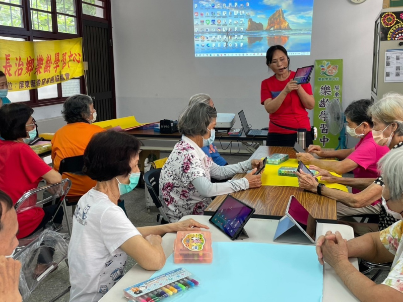 執行長引導長輩學員運用平板學習，專注操作與互動，培養樂齡數位技能。