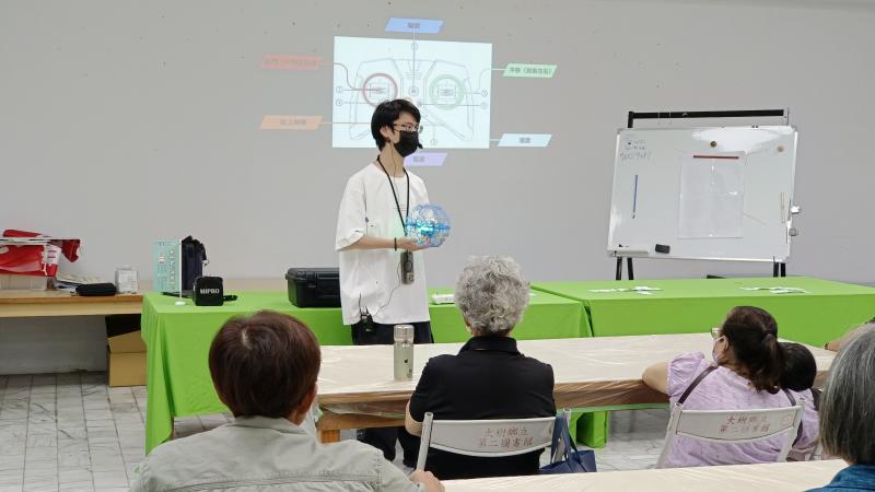 「銘裕老師以幽默風趣的方式，為學員講解無人機足球操作要領，並介紹如何安全飛行。學員們聚精會神地聆聽，現場氣氛溫馨而專注。」