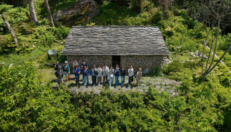 步行瓦拉米步道至佳心石板屋，使用空拍機記錄下參訪師生團隊與石板屋的合影。
