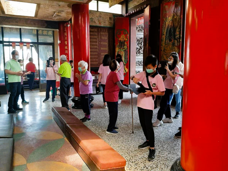 廟內,學生與社區長輩分組進行數位寫生,利用平板拍攝廟宇建築與人文特色。