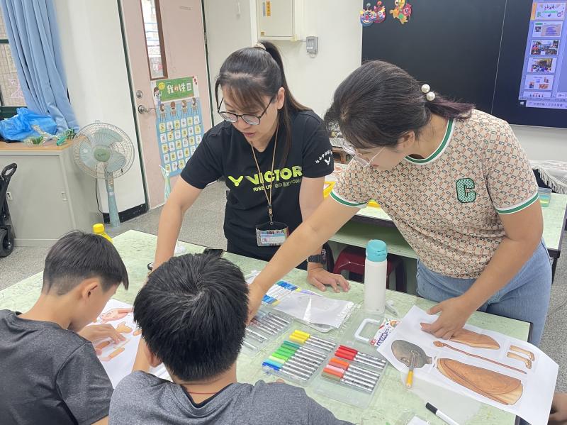 老師溫柔陪伴，學童專注為3D戲偶彩繪上色。