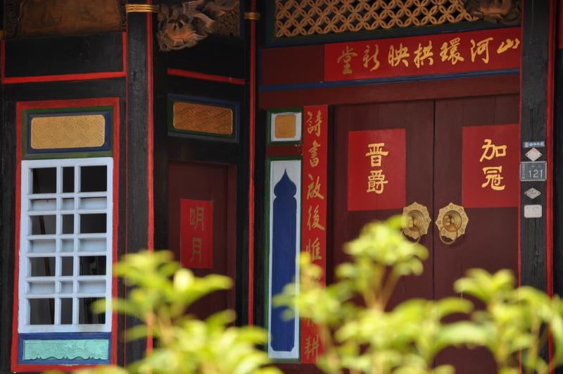 採光與通風的橫披窗由精巧的木條榫接，以古錢、花朵等不同圖案組成，富有變化