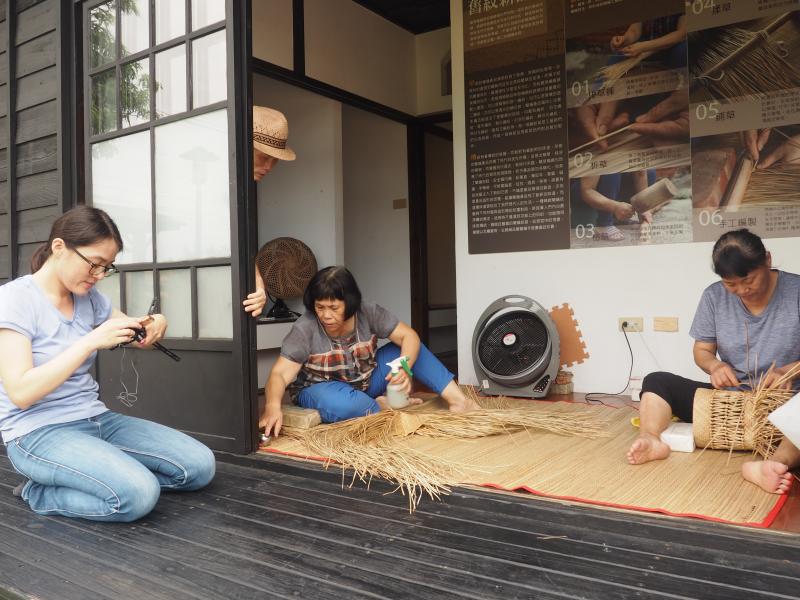 工藝師正編織藝品，一旁遊客也拿起手機拍攝喔