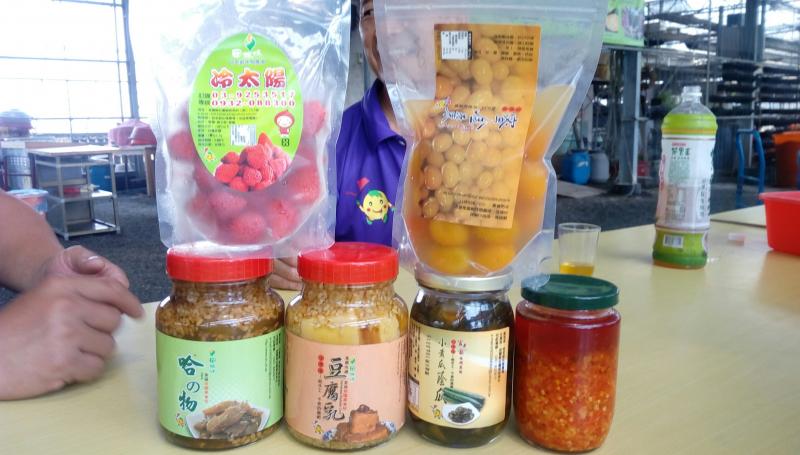 桌上陳列著農產品，有罐裝豆腐乳、哈密瓜醬瓜、冷太陽、蜜金棗、小黃瓜蔭瓜。