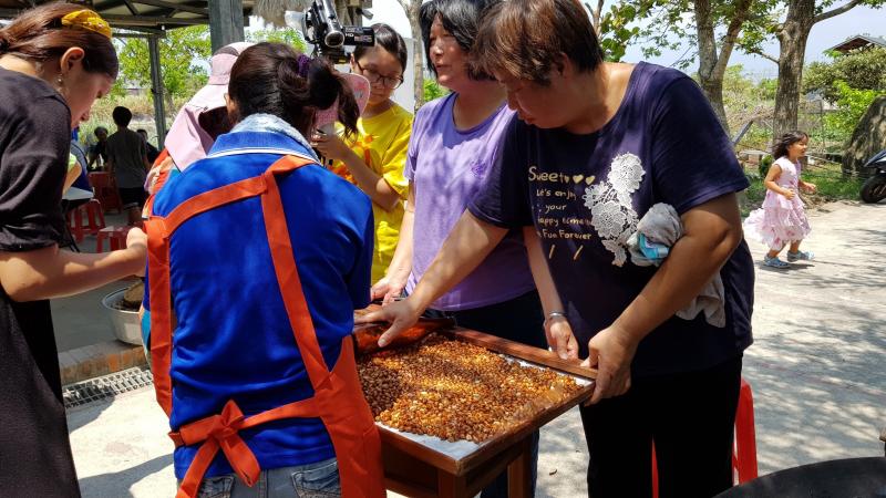 社區長輩指導遊客作花生糖