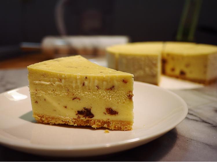 金黃的重乳酪蛋糕，由碎餅乾作為底部，上方則是黃色的乳酪蛋糕本體。