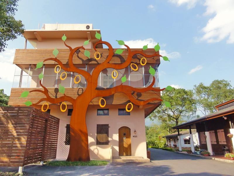 橘之鄉的屋外是以金棗樹做為形象的公共藝術，橙色的房屋與部分木造的建材形成與自然融合的建築。