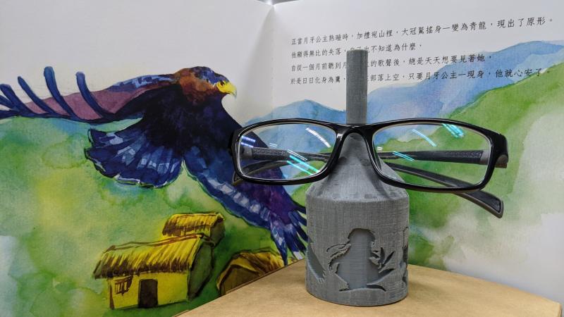 《月牙公主》一書與其3D列印文創商品眼鏡架合影。
