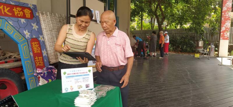 中埔DOC推廣活動志工協助民眾加入DOC粉絲專頁並與民眾說明平板借用服務。
