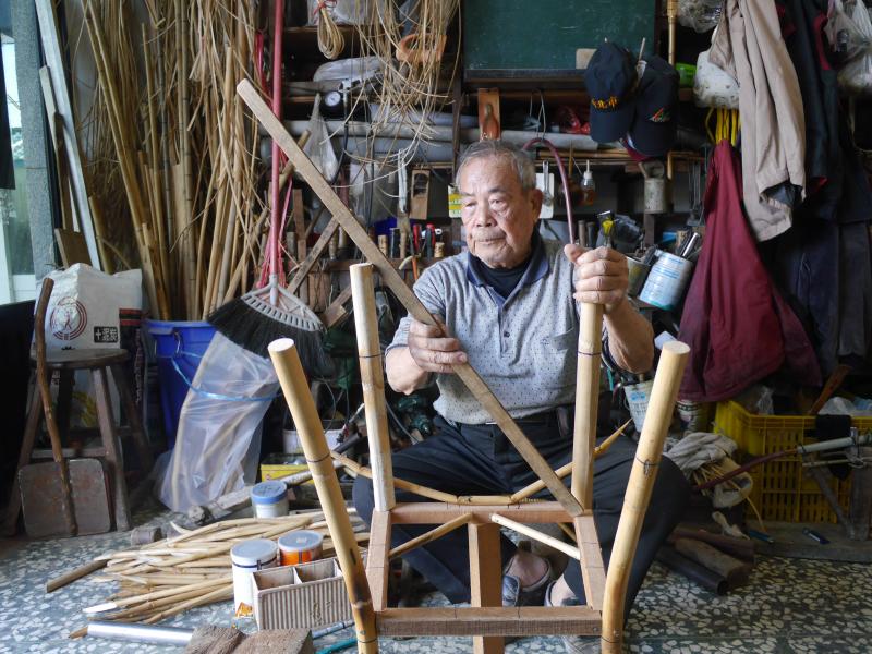 吳錦達進行手工編織藤椅過程