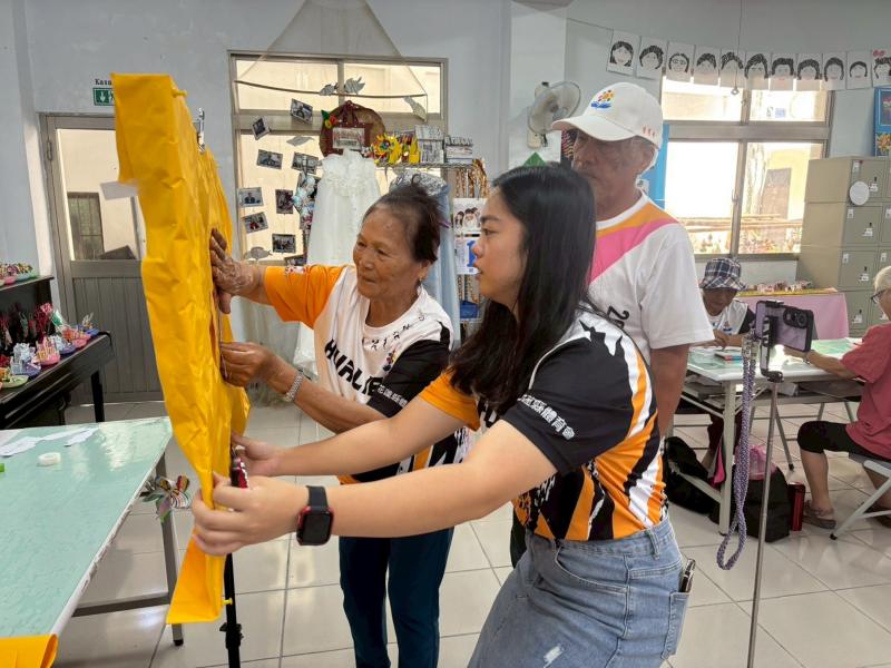 站上服務員協助長著貼自己印出的相片在板子上