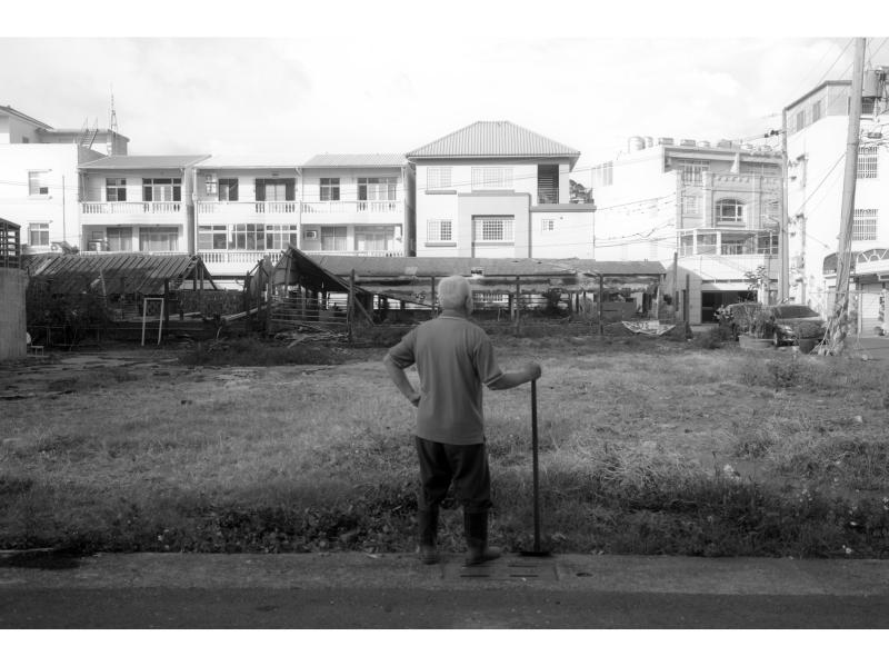 在湖內區的一隅，留有一片農地，拿著鋤頭望著眼前的風景