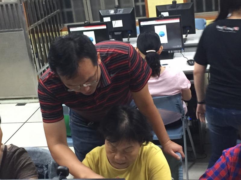 主任指導阿嬤操作平板