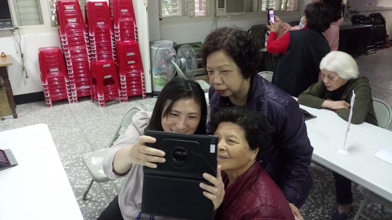 學員拿起平板和他人一起自拍。