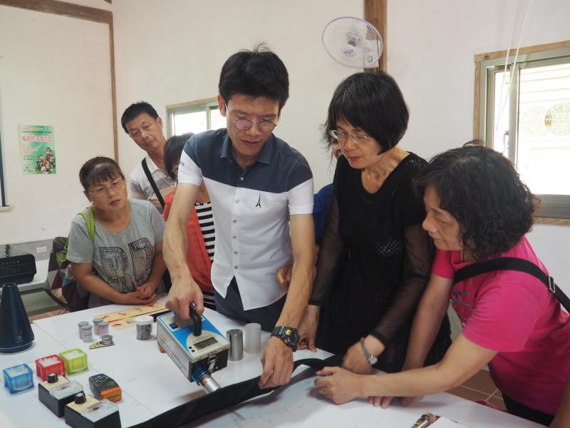 老師拿著「游離輻射偵測器」，偵測護腰帶輻射能量