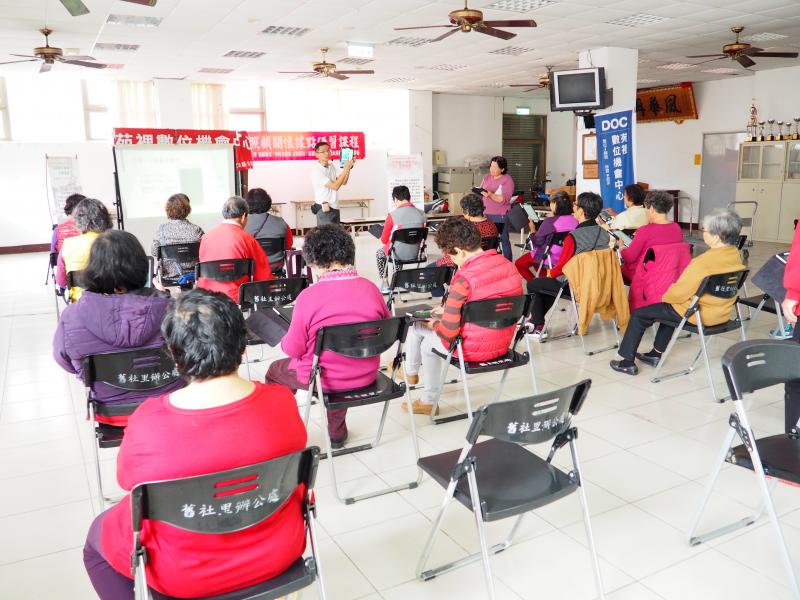 老師認真地教導舊社里民平板電腦中