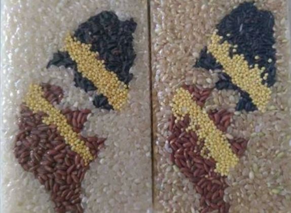 小農用白米/糙米/紅米/紫米/小米五種不同顏色的米手工製作出各式圖案的拌手禮，拼成一個台灣的形狀。
