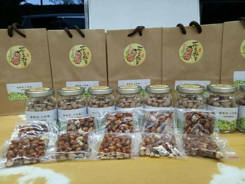 將製作的成品依序排列在桌上，前方一列為小袋裝花生糖，中間一列為罐裝乾燥花生，最後一列則為組合包。