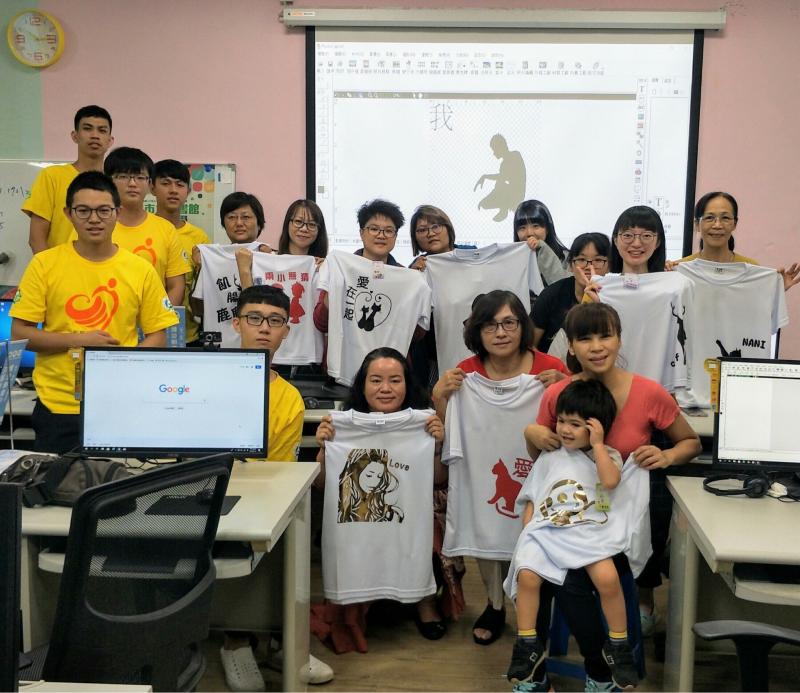 學員們拿著自製的T-shirt在教室前方合照。