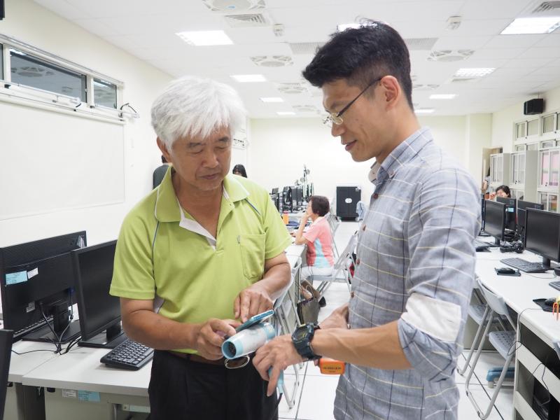 老師和學員一起偵測手機的輻射能量多寡