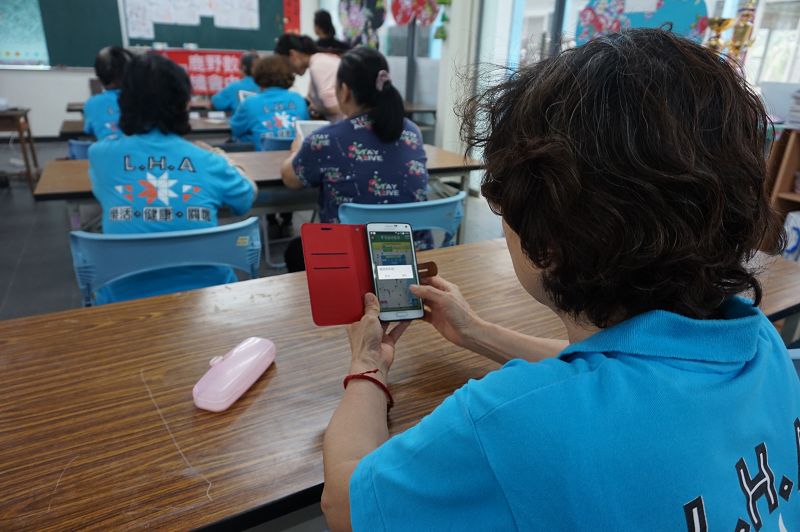 學員拿出自己的手機下載樂圾通APP-設定縣市、鄉鎮及區域設定