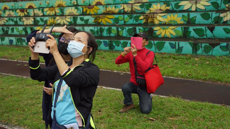 <p>在竹山數位機會中心開設的空拍課程中，雖然是三人共用一台空拍機，但學員仍抓緊機會練習各式的拍照取材。</p>